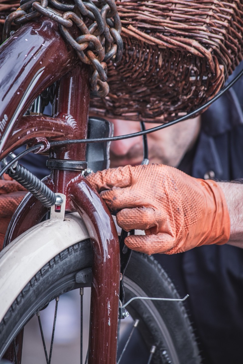 A mechanic adjusting the front brake of a classic bicycle